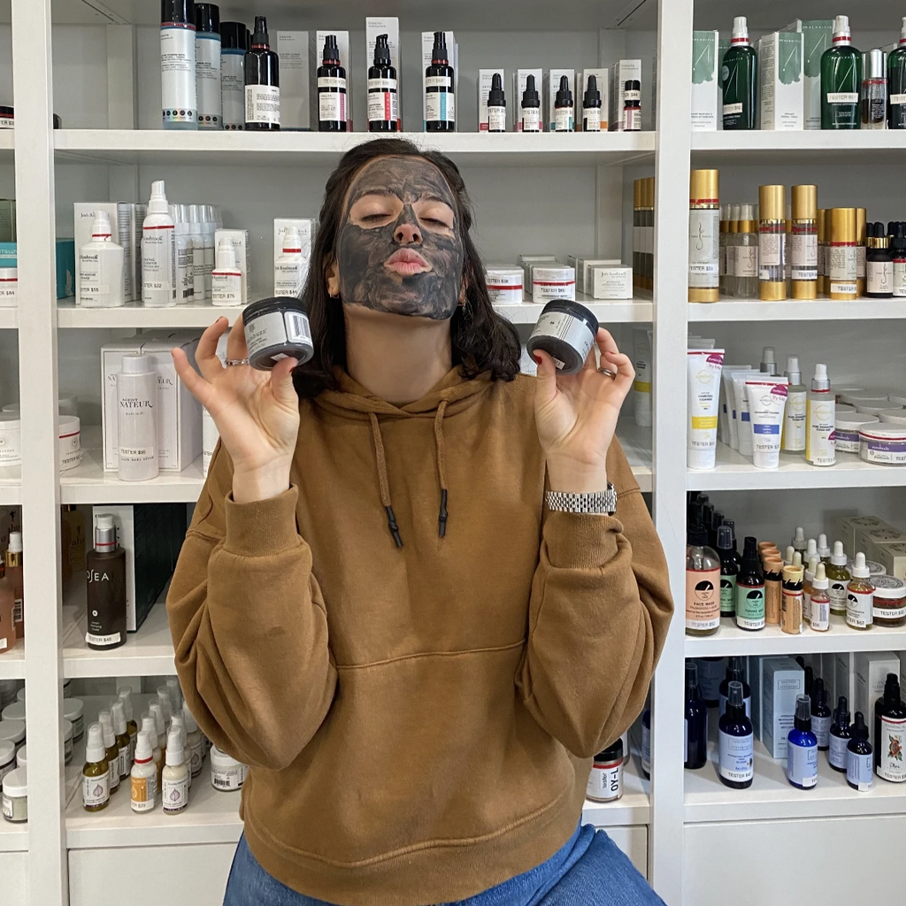 crazy young woman wearing a charcoal mask on her face