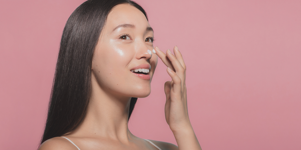 woman using moisturizing cream on her face junkfeemarket